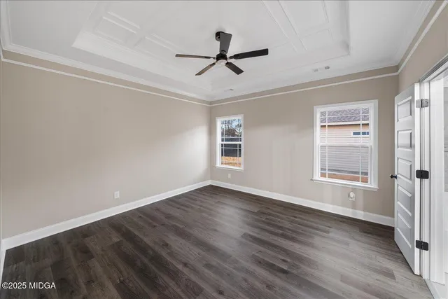 a view of empty room with wooden floor and ceiling fan