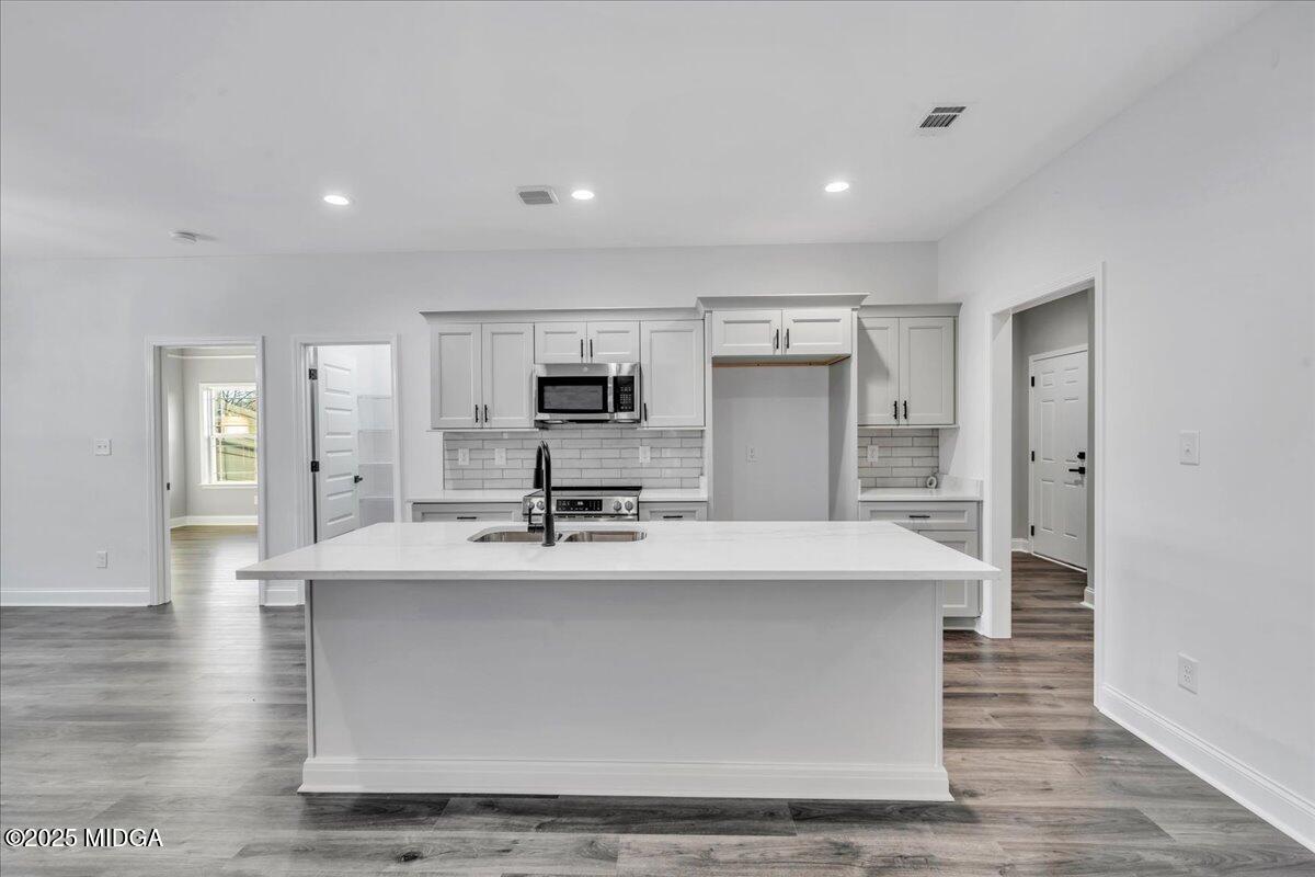 103 Early Drive Byron, GA 31008 - Photo 16 of 44 a large kitchen with stainless steel appliances a large counter top a stove and a refrigerator