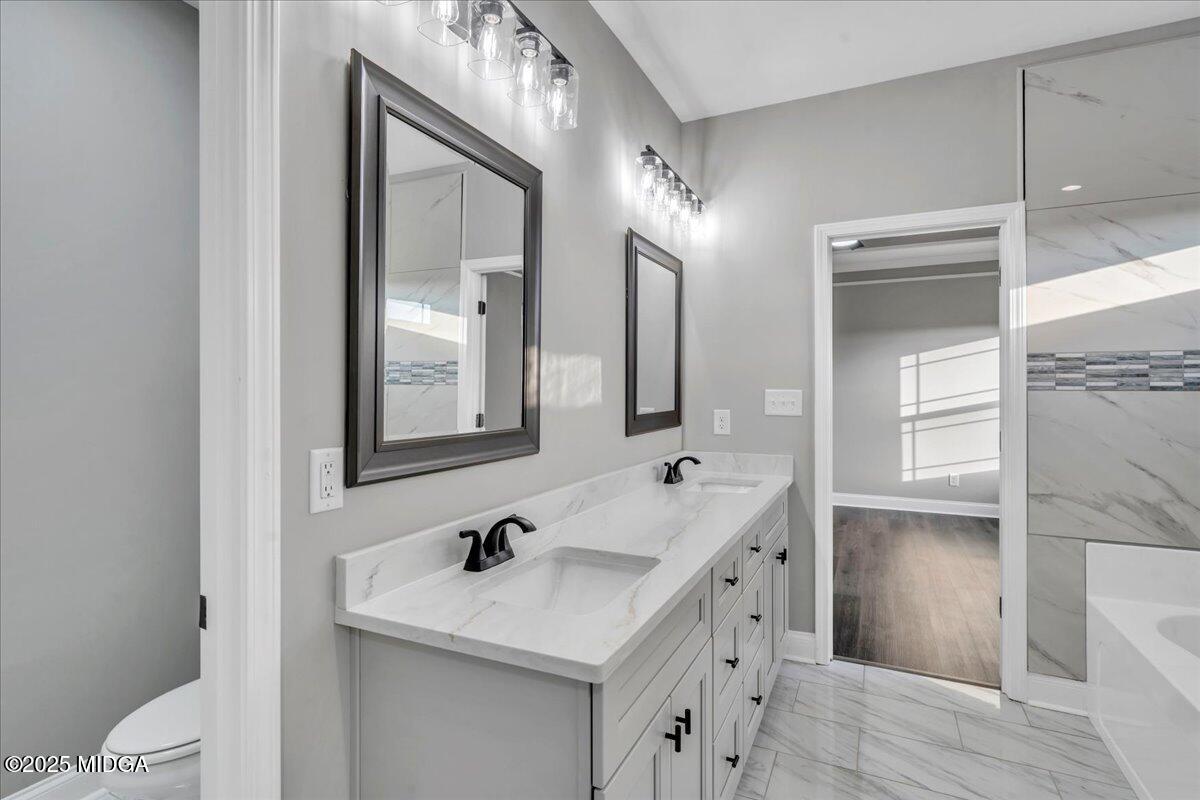 103 Early Drive Byron, GA 31008 - Photo 30 of 44 a bathroom with a sink a toilet a vanity and mirror