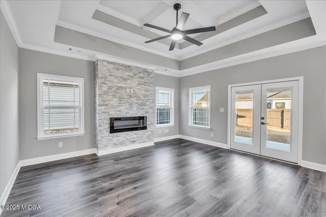 a view of a livingroom with a ceiling fan wooden floor and a ceiling fan