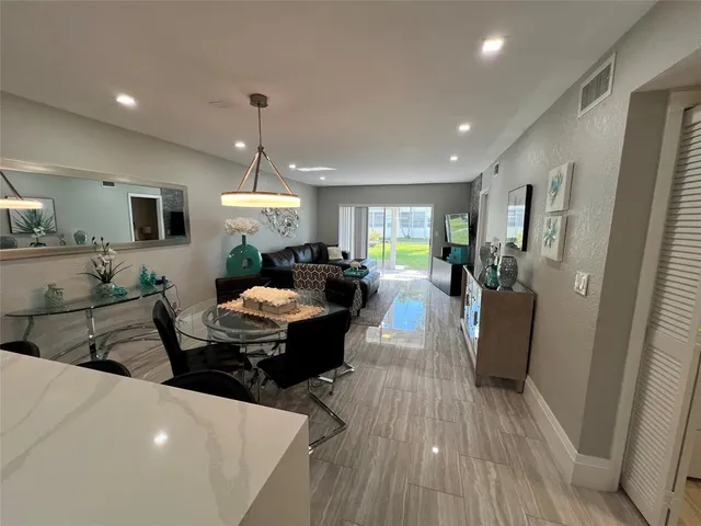 a living room with furniture a dining table wooden floor and a fireplace