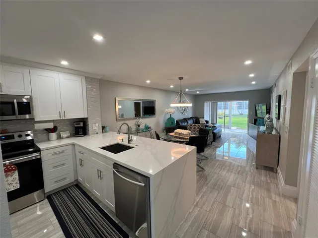 a kitchen with a sink white cabinets and stainless steel appliances