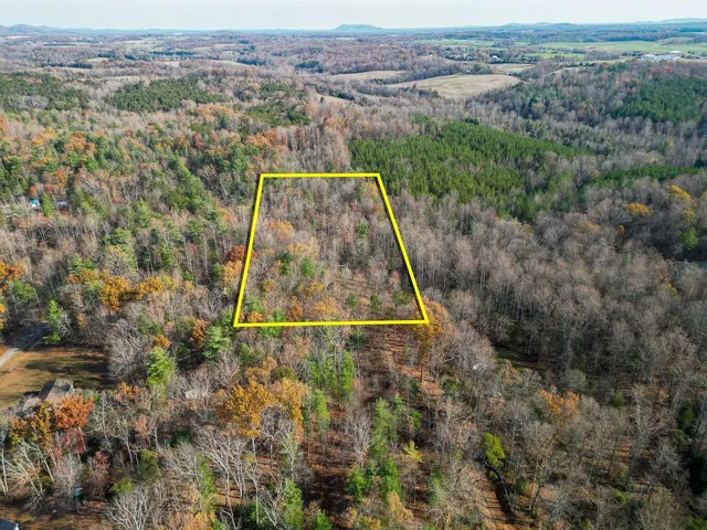 an aerial view of a house with a yard and lake view