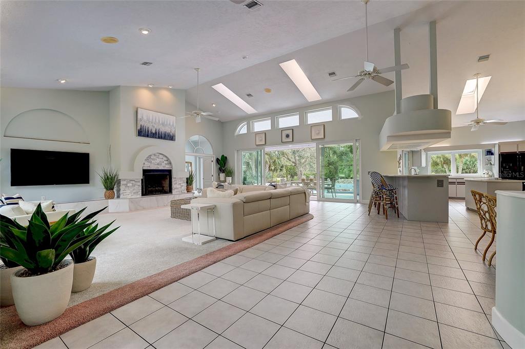 181 South Auburn Road Venice, FL 34292 - Photo 8 of 91 a living room with furniture a flat screen tv and a fireplace