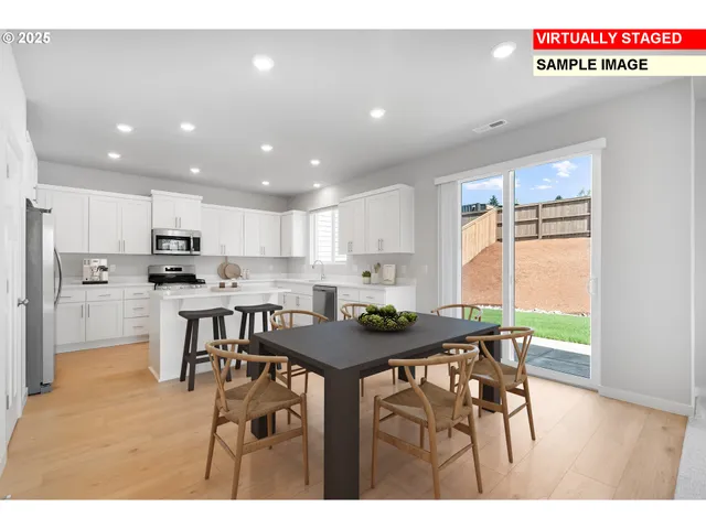 a kitchen with stainless steel appliances granite countertop table chairs sink and cabinets