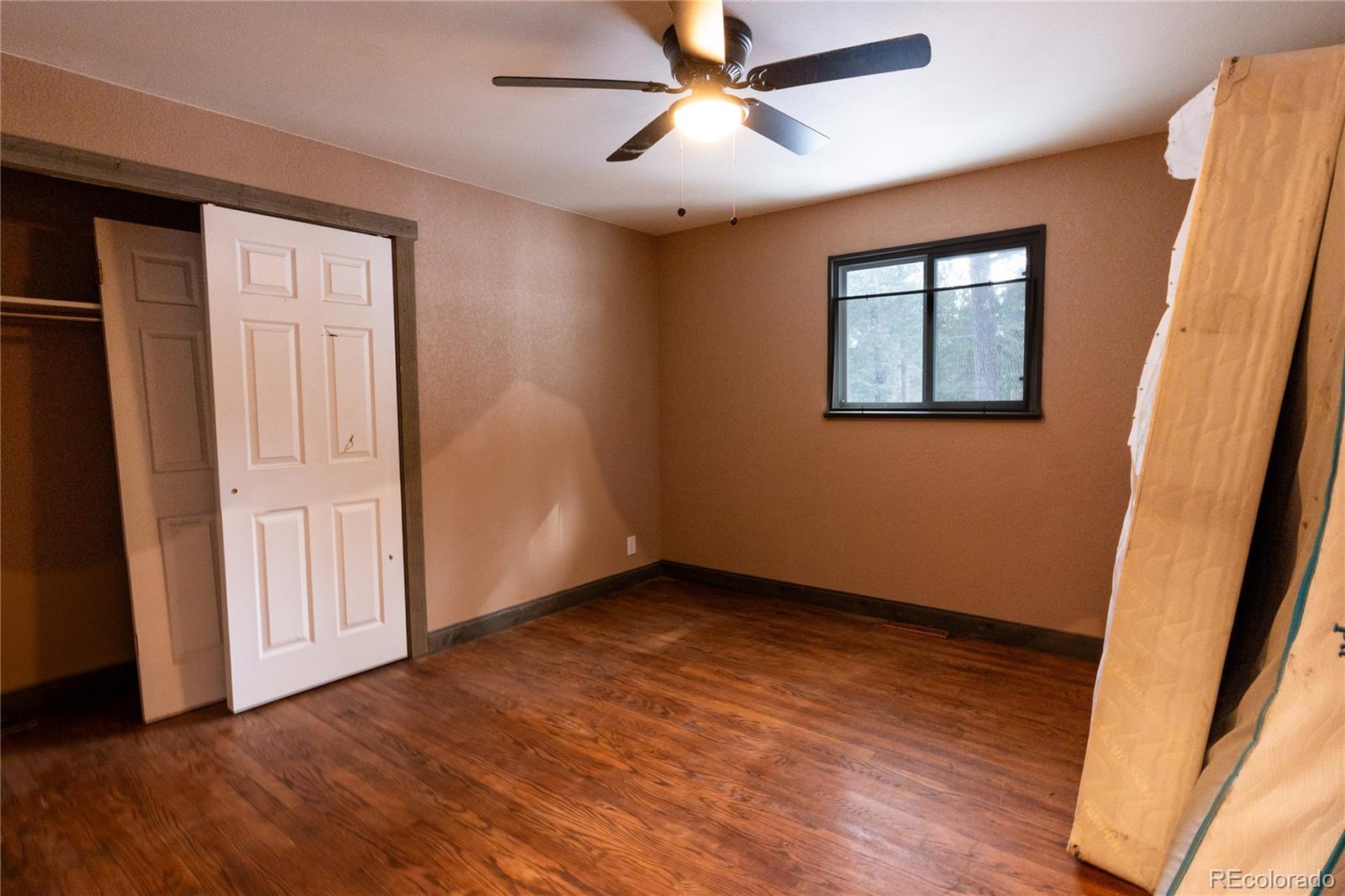 983 Wagon Trail Road Evergreen, CO 80439 - Photo 20 of 47 a view of an empty room with wooden floor and a window
