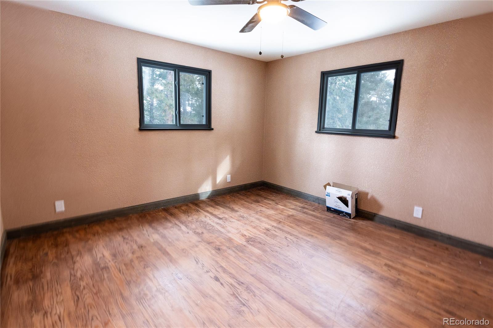 983 Wagon Trail Road Evergreen, CO 80439 - Photo 23 of 47 a view of an empty room with wooden floor and a ceiling fan