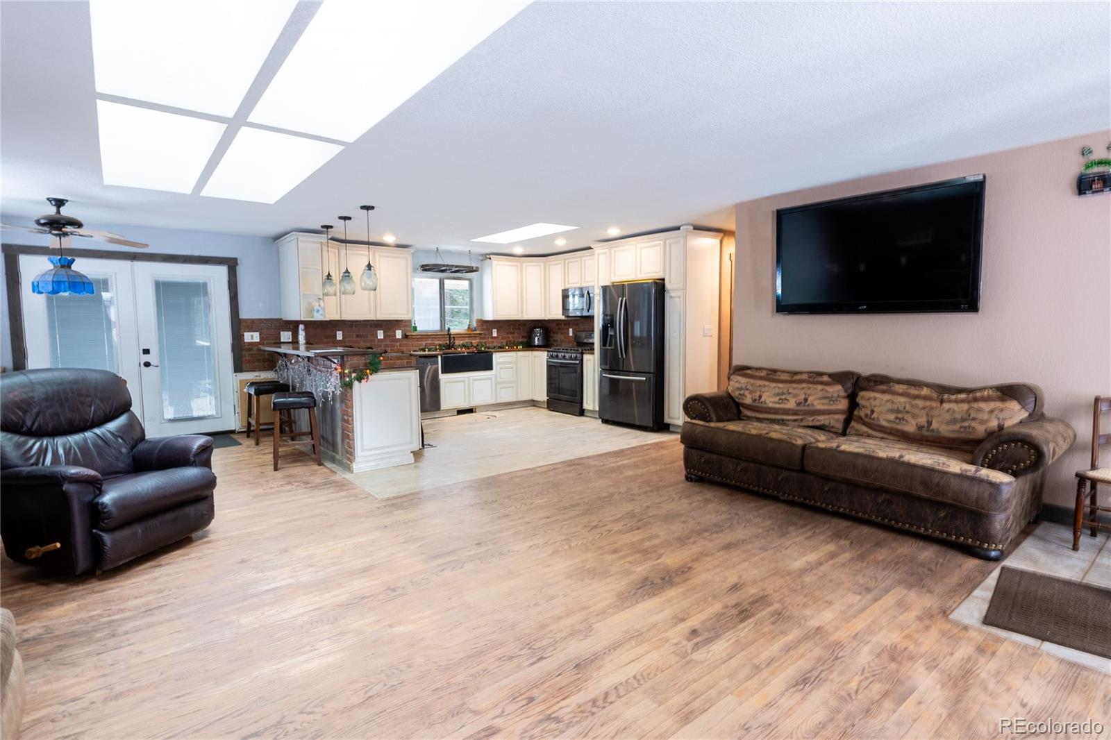 983 Wagon Trail Road Evergreen, CO 80439 - Photo 5 of 47 a living room with furniture and a flat screen tv