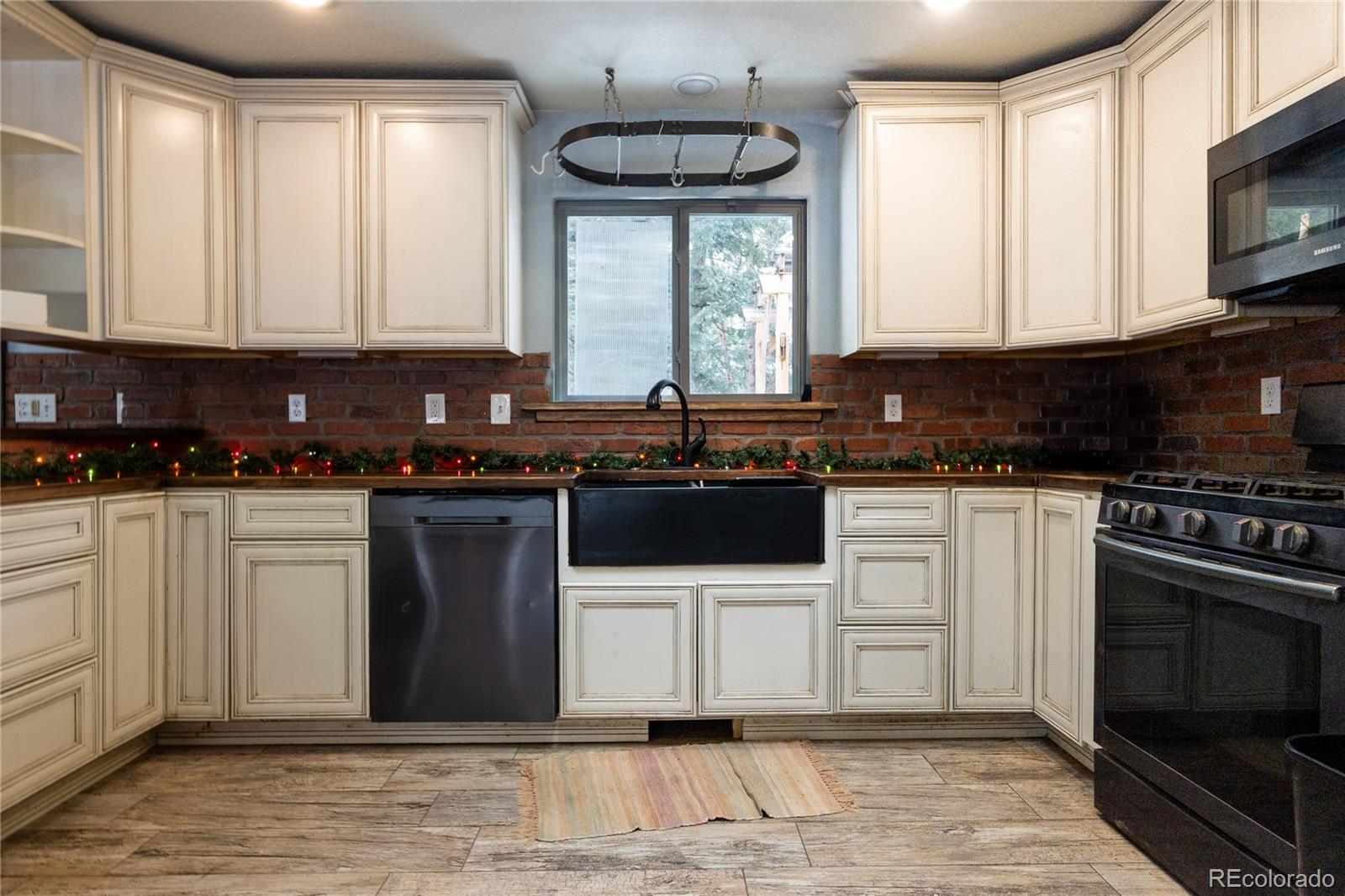 983 Wagon Trail Road Evergreen, CO 80439 - Photo 7 of 47 a kitchen with stainless steel appliances a stove a sink and a microwave