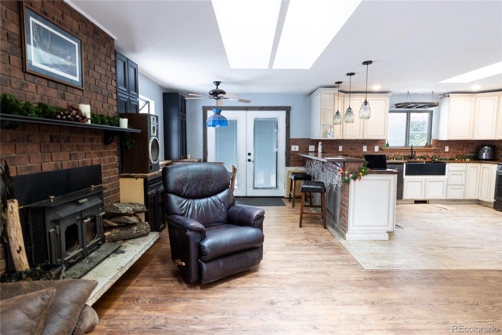 983 Wagon Trail Road Evergreen, CO 80439 - Photo 10 of 47 a living room with furniture a fireplace and a kitchen view