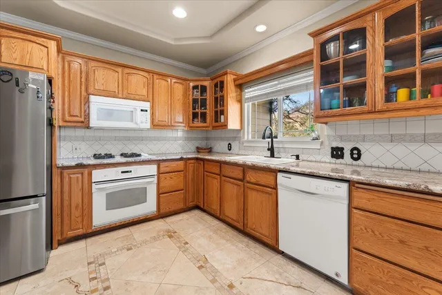 a kitchen with granite countertop a refrigerator stove top oven and sink