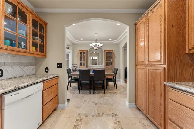 a dining room with wooden floor a chandelier a wooden table and chairs
