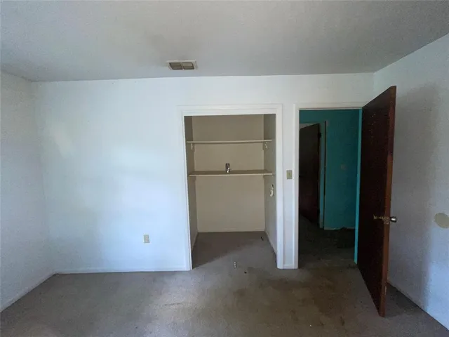 an empty room with closet and wooden door