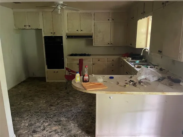 a kitchen with a sink a refrigerator and cabinets