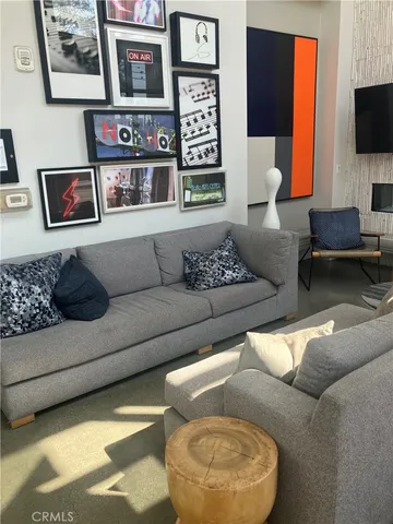 a living room with couches and kitchen view with wooden floor
