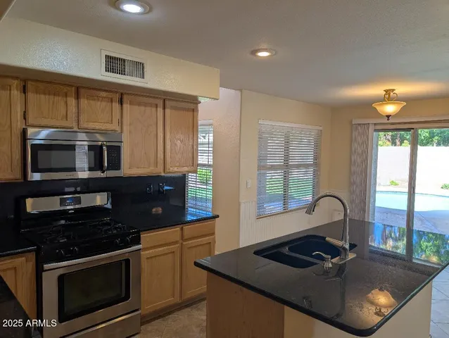 a kitchen with granite countertop a stove and a sink