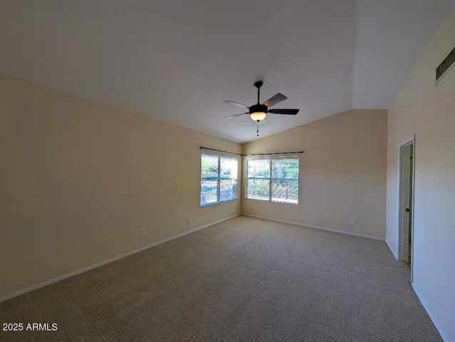 en empty room with windows and ceiling fan