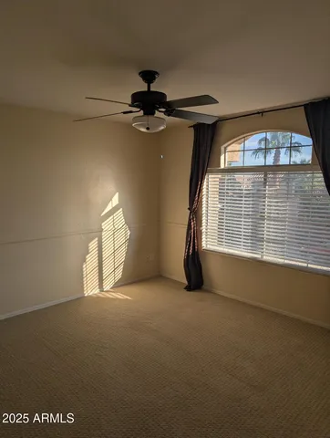 en empty room with windows and fan