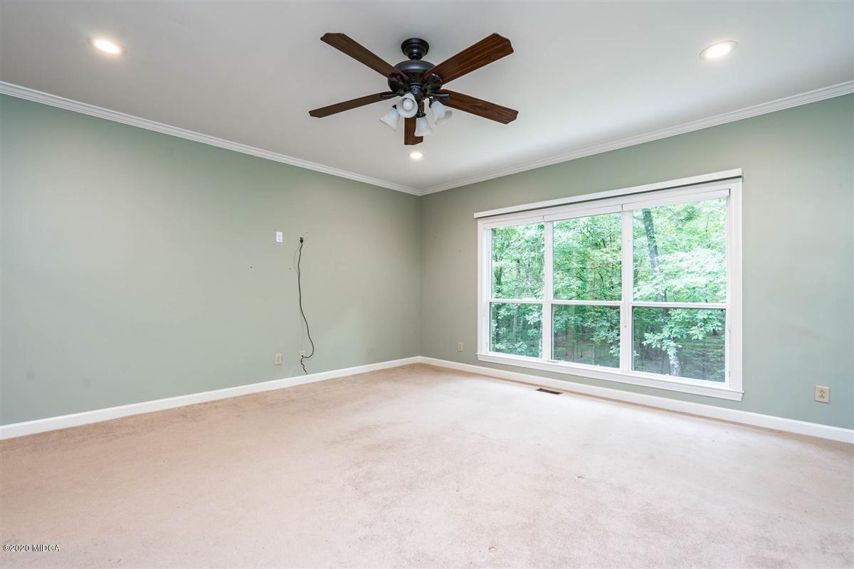 1934 Reedy Creek Road Forsyth, GA 31029 - Photo 45 of 51 an empty room with chandelier fan and windows