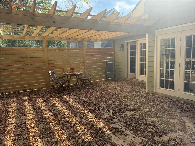 a view of a backyard with chairs and table in the patio