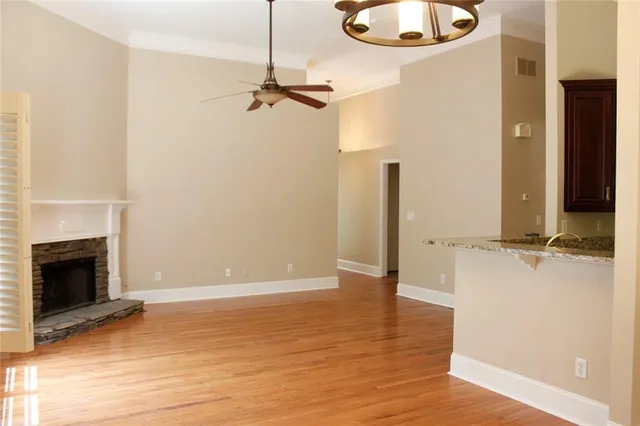 an empty room with wooden floor a fireplace and windows
