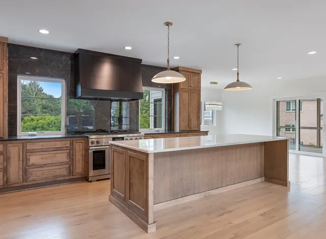 a kitchen with stainless steel appliances granite countertop a refrigerator and a stove top oven