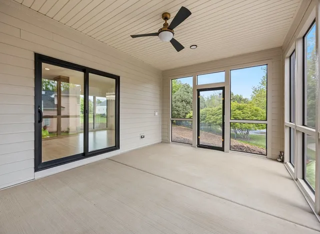 a bedroom with a bed painting on wall and a large window