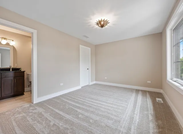 a view of empty room with window and wooden floor