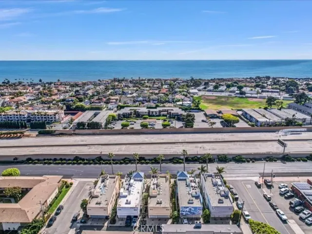 an aerial view of residential houses with outdoor space and trees