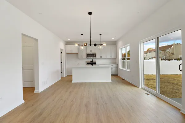 a kitchen with stainless steel appliances granite countertop a sink a stove a refrigerator and white cabinets with wooden floor