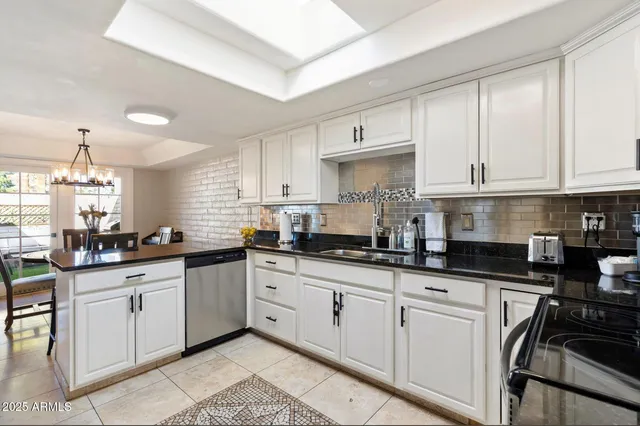 a kitchen with granite countertop a sink a stove and cabinets