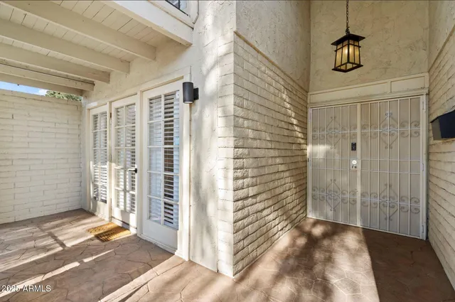 a view of a hallway with wooden floor and a bathroom