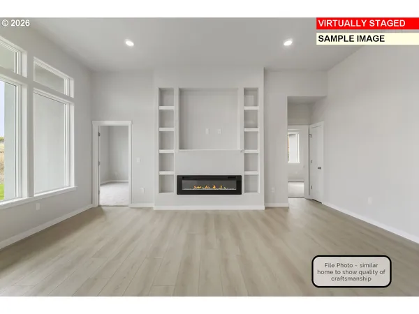 a kitchen with kitchen island granite countertop a stove a sink a refrigerator and white cabinets with wooden floor