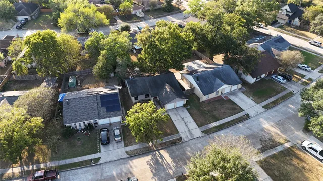 an aerial view of a house with a yard potted plants and large tree