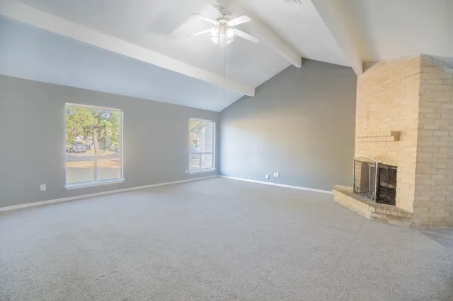 an empty room with windows and chandelier fan