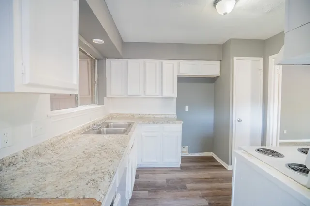 a kitchen with granite countertop a sink and a stove