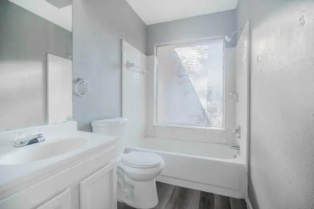 a bathroom with a bathtub shower sink vanity and a toilet
