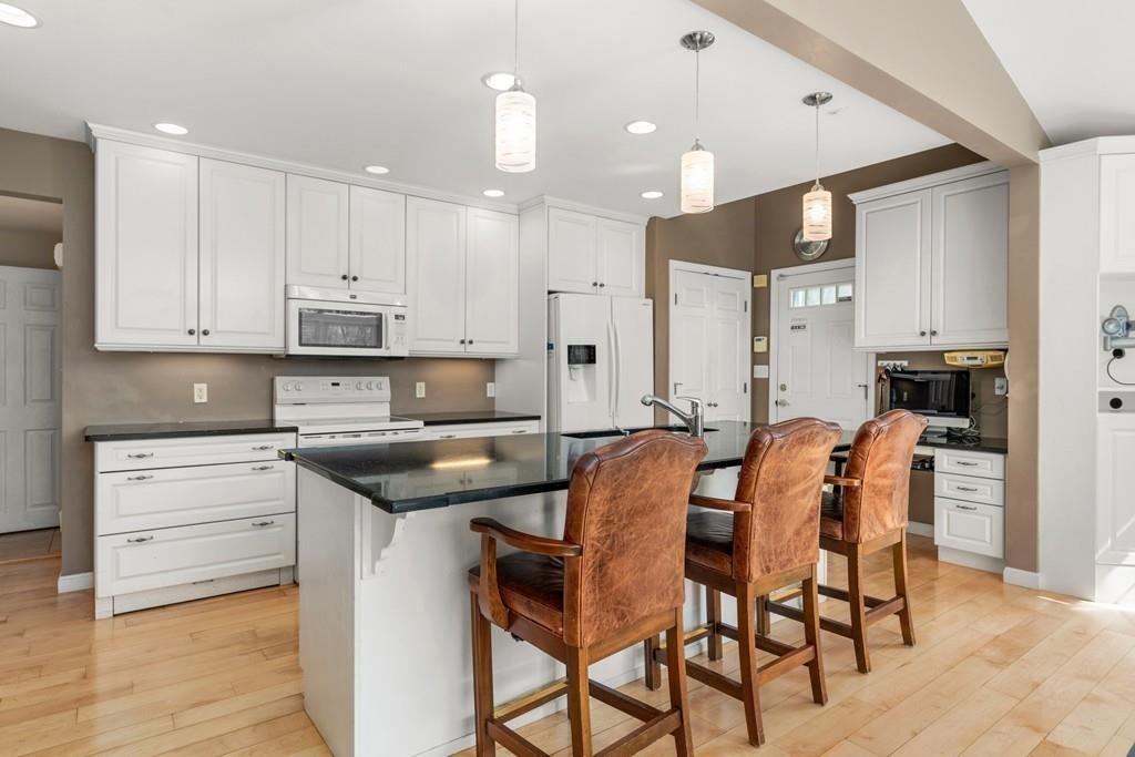 242 Old Stonebridge Road Wayland, MA 01778 - Photo 5 of 19 a kitchen with stainless steel appliances kitchen island granite countertop a table chairs sink and cabinets