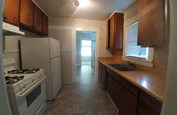 a kitchen with stainless steel appliances granite countertop a stove a sink and a refrigerator