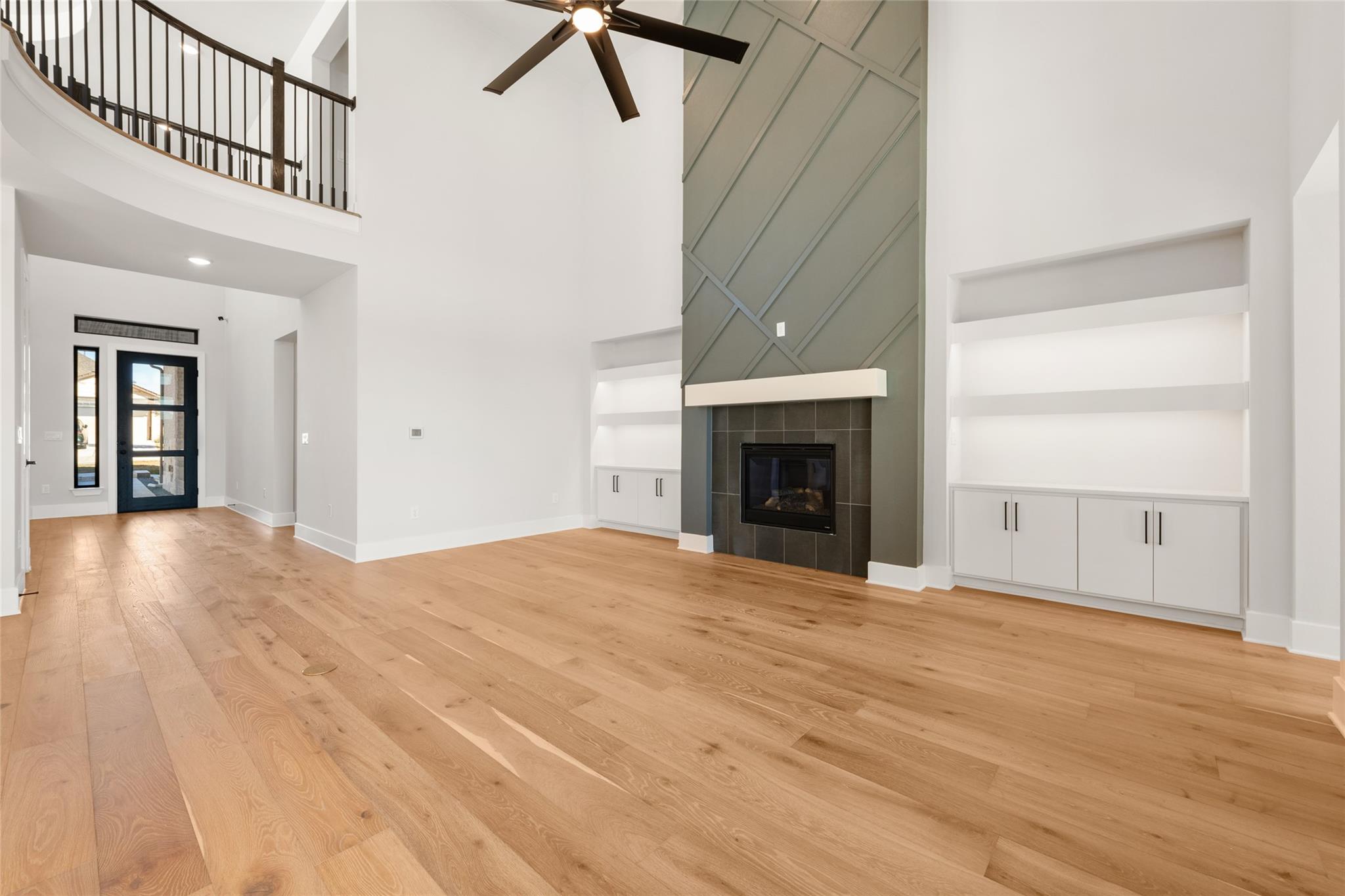 6216 Bower Well Road Austin, TX 78738 - Photo 7 of 31 an empty room with wooden floor fireplace and windows