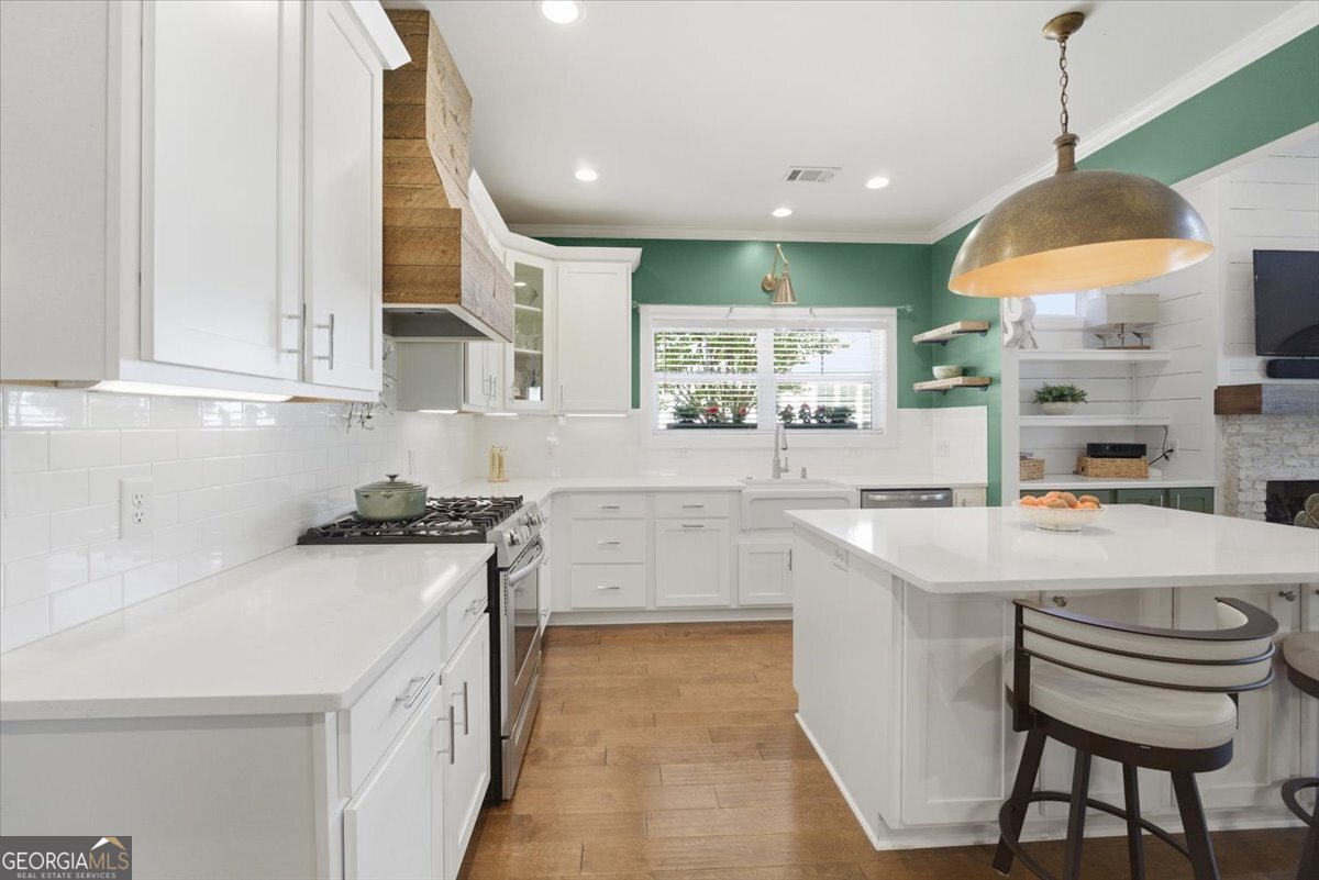 731 Markhams Drive Madison, GA 30650 - Photo 16 of 68 a kitchen with kitchen island a stove a sink a center island and a refrigerator