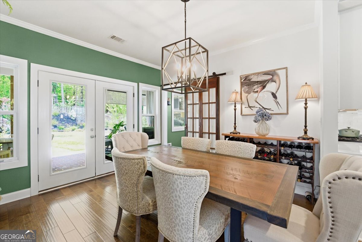 731 Markhams Drive Madison, GA 30650 - Photo 18 of 68 a dining room with furniture a chandelier and wooden floor