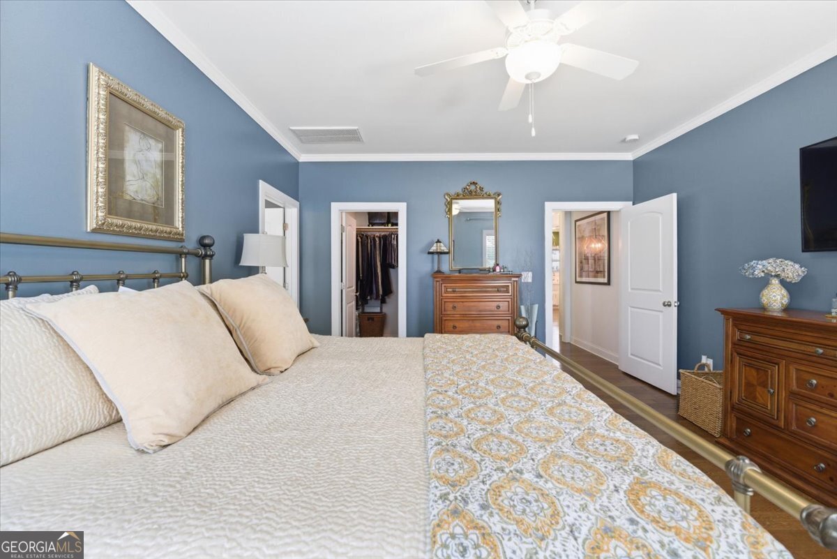 731 Markhams Drive Madison, GA 30650 - Photo 24 of 68 a bedroom with a large bed and wooden floor