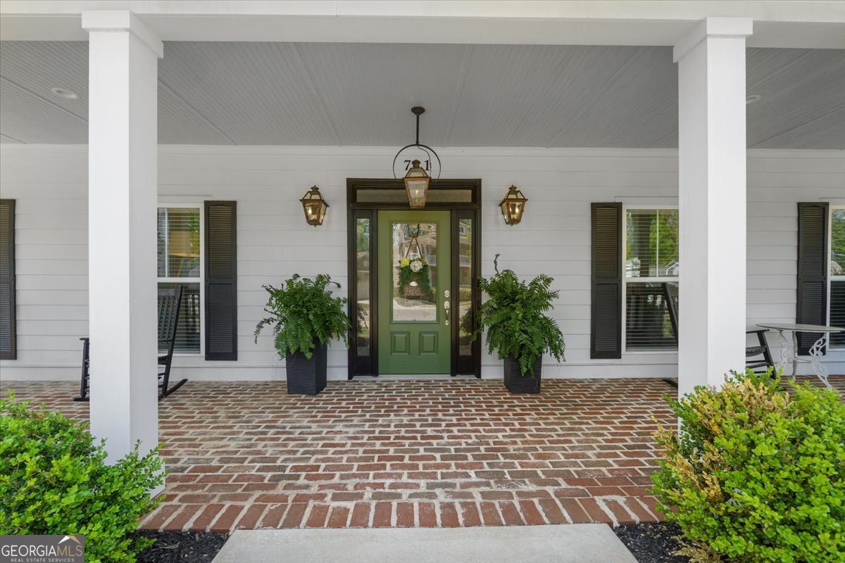 731 Markhams Drive Madison, GA 30650 - Photo 3 of 68 a view of a house with potted plants