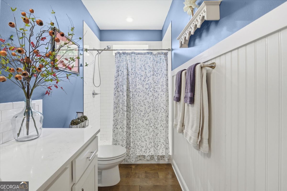 731 Markhams Drive Madison, GA 30650 - Photo 40 of 68 a bathroom with a sink a toilet and shower curtain