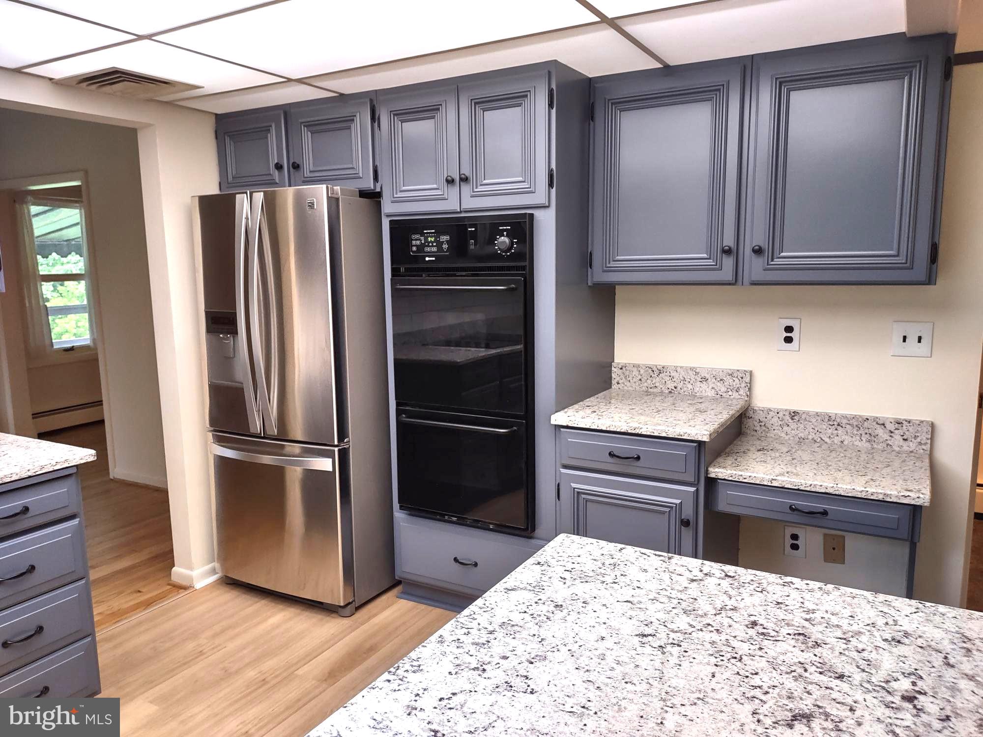 4103 Kincaid Road Baldwin, MD 21013 - Photo 26 of 73 a kitchen with stainless steel appliances kitchen island granite countertop a refrigerator stove and sink with wooden floor