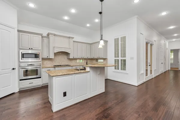 a kitchen with stainless steel appliances granite countertop a sink a stove and a refrigerator
