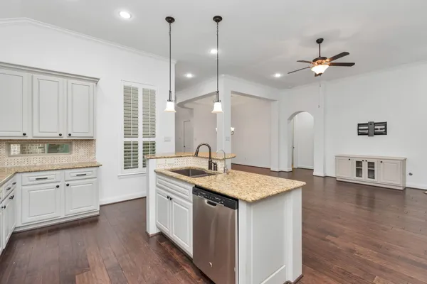 a kitchen with stainless steel appliances white cabinets and wooden floors