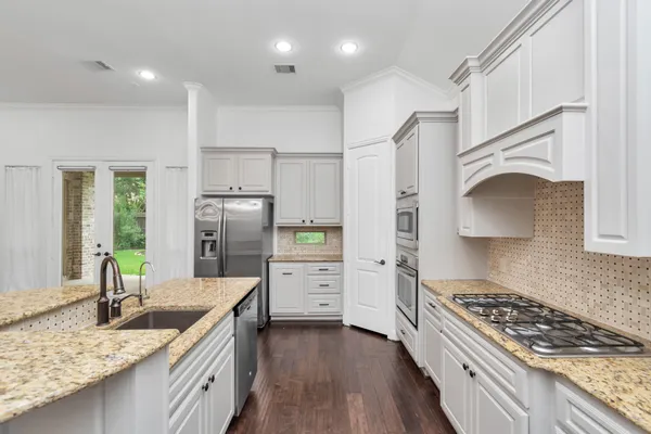 a kitchen with refrigerator cabinets and wooden floor