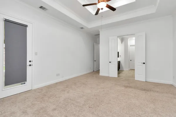 an empty room with a ceiling fan and windows